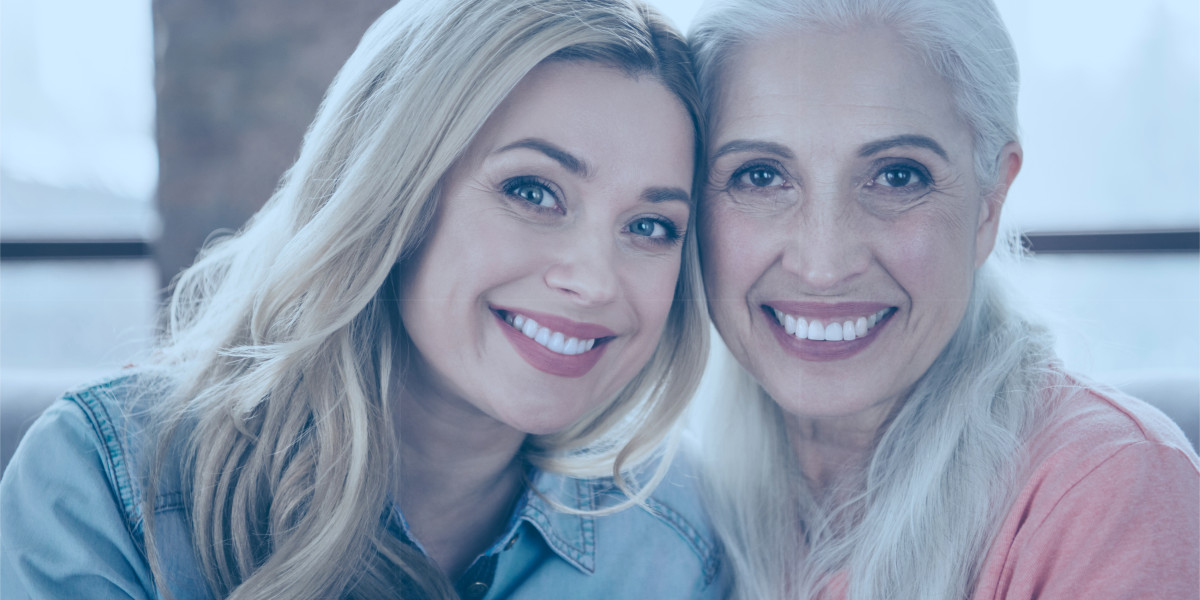 Mutter und Tochter sitzen eng nebeneinander und lächeln in die Kamera