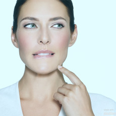 Frau beißt sich auf die Unterlippe und schaut zur Seite