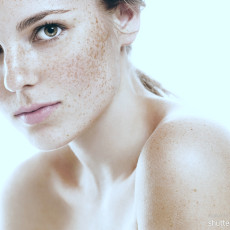 Frau mit Sommersprossen schaut in die Kamera